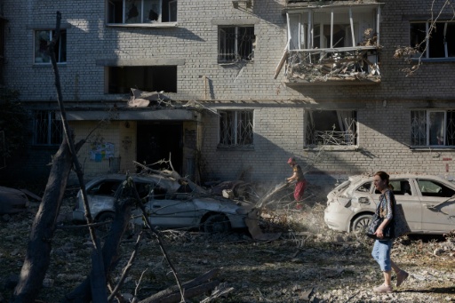 Une femme marche près d'un immeuble résidentiel endommagé à la suite d'une frappe à Kiev, le 20 août 2026 — Tetiana DZHAFAROVA / AFP