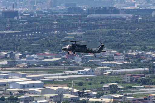 A Taiwanese Army UH-60M Black Hawk utility helicopter flies over residential neighbourhoods on the opening day of the Han Kuang military exercise in Kaohsiung — cheng-chia huang / AFP