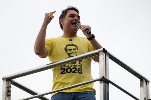 El senador Flavio Bolsonaro, fotografiado luciendo una imagen del rostro de su padre, ha tenido dificultades para liberarse de la sombra del expresidente. — Pablo PORCIUNCULA / AFP