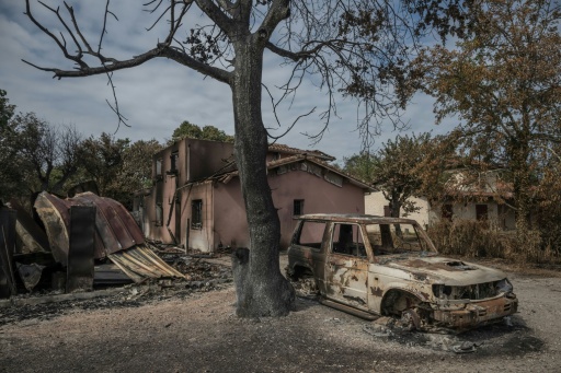 Une voiture calcinée devant une maison détruite par l'incendie, au Porge, dans le sud-ouest de la France, le 31 juillet 2026 — Ed JONES / AFP