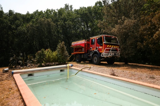 Un camion de pompiers pompe l'eau d'une piscine au cours d'un incendie à Montfort-sur-Argens, dans le Var, le 1er août 2026 — Clement MAHOUDEAU / AFP