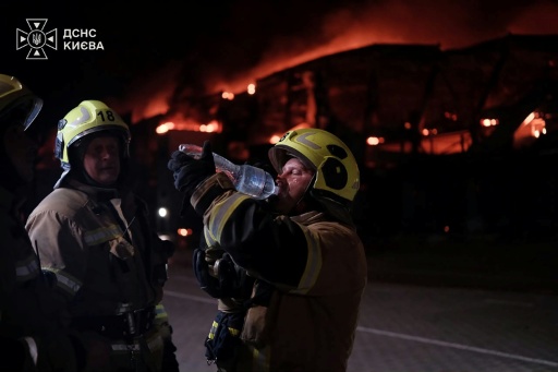 Rescuers outside a warehouse premises damaged following Russian strikes in Kyiv — Handout / AFP