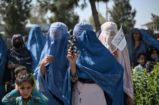 Une femme en burqa utilise son téléphone portable lors des célébrations par les dirigeants talibans du cinquième anniversaire de leur retour au pouvoir, le 15 août 2026 à Kandahar — Sanaullah SEIAM / AFP