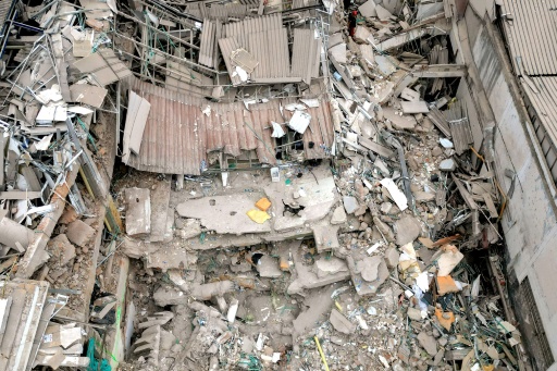 Une vue aérienne montre un chien marchant au milieu des décombres d'un bâtiment effondré après un séisme de magnitude 7,4 à Pereira, en Colombie, le 15 août 2026 — Luis ACOSTA / AFP