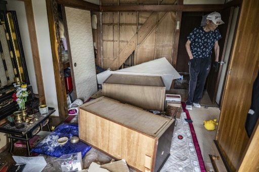 Akira Motoda walks inside his house damaged by a 7.1-magnitude earthquake — Yuichi YAMAZAKI / AFP