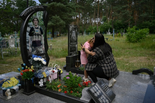 Lioudmyla (à droite), 27 ans, veuve du soldat ukrainien Andriï Doubnytsky, et sa fille Mia (à gauche), 4 ans, visitent sa tombe dans un cimetière du village de Stepantsi, dans la région de Tcherkassy, le 7 juillet 2026.