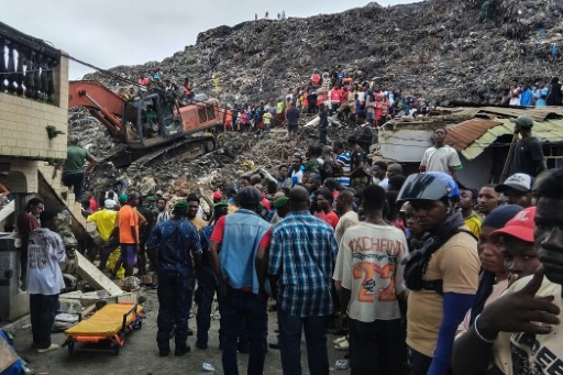 Des résidents du quartier Dar es Salaam et des secouristes s'activent le 23 août 2026 pour tenter de retrouver des survivants et des victimes après l'éboulement d'une décharge sur plusieurs habitations à Conakry, en Guinée — - / AFP