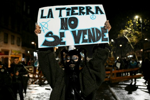 Une manifestante porte un écriteau "La terre n'est pas à vendre" lors d'un rassemblement à Buenos Aires, le 6 août 2026 — Luis ROBAYO / AFP