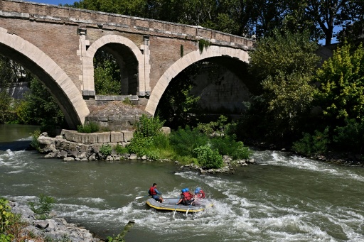 Passing Tiber Island, the river's current picks up, splashing the rafters — Andreas SOLARO / AFP