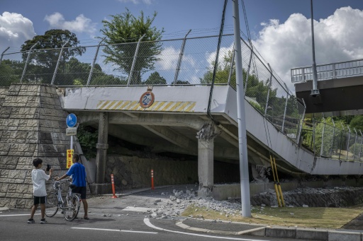 Children look at a section of a collapsed road in Hikawa town, in Japan's quake-hit Kumamoto region — Yuichi YAMAZAKI / AFP