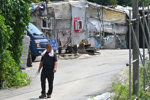 A man walks in the shanty village of Guryong on the outskirts of Gangnam district in Seoul — Jung Yeon-je / AFP