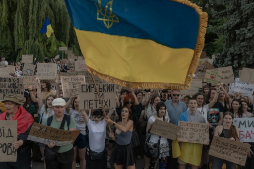 Des manifestants brandissent un drapeau ukrainien lors d’une manifestation contre la décision du président ukrainien de limoger le ministre de la Défense Mykhaïlo Fedorov, à Kiev le 18 juillet 2026 — Roman PILIPEY / AFP