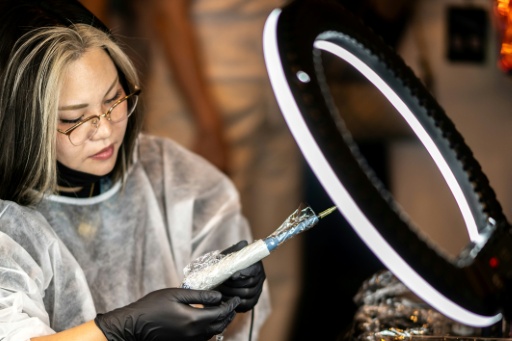 A scalp tattoo artist conducting a demonstration during a contest in Naha, Okinawa Prefecture — Philip FONG / AFP