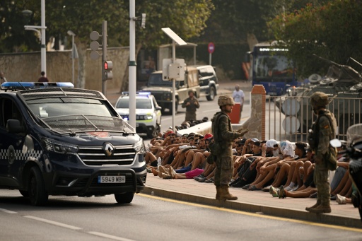 Soldados españoles vigilan a migrantes en el enclave español de Ceuta, el 1 de agosto de 2026 — JORGE GUERRERO / AFP