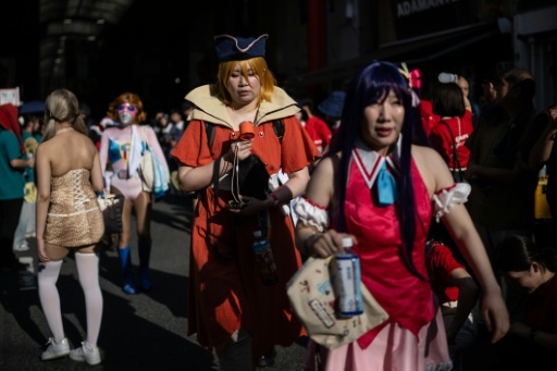 Une personne déguisée utilise un ventilateur portable pour se rafraîchir dans la rue, lors de la deuxième journée du World Cosplay Summit 2026 à Nagoya, le 1er août 2026 — Philip FONG / AFP