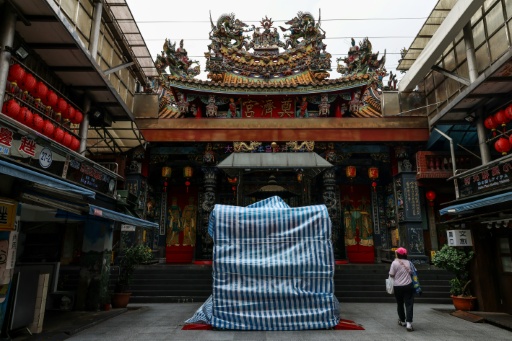 Statues outside a temple in Keelung are covered with protective tarpaulins ahead of the arrival of Typhoon Bavi