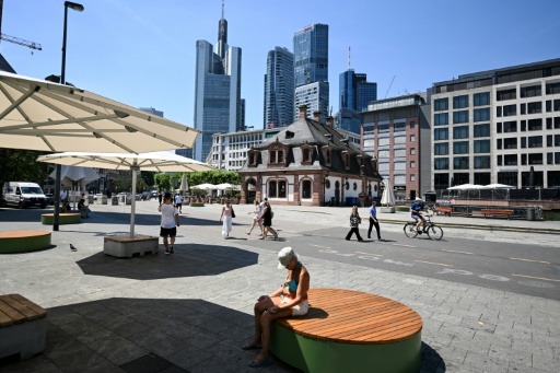 Des passantes se protègent du soleil sous une ombrelle à Berlin, pendant une vague de chlauer, le 26 juin 2026 — Tobias SCHWARZ / AFP