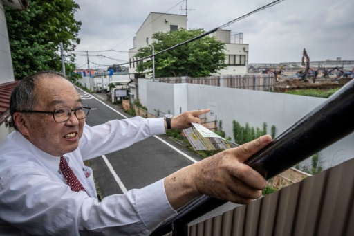 Yasuo Yamazaki, représentant d'un collectif de citoyens inquiets de la construction d'un centre de données, montre le site du projet à Hino, dans la préfecture de Tokyo, au Japon, le 30 juin 2026 — Yuichi YAMAZAKI / AFP