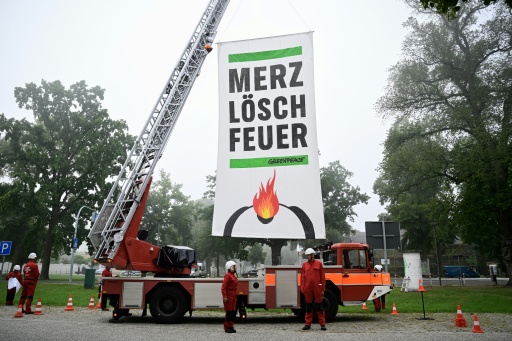Greenpeace activists near the cabinet retreat set up a fire engine with a banner demanding: 'Merz, extinguish the fire' — John MACDOUGALL / AFP
