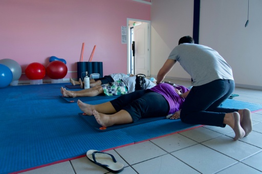 Un entraîneur aide des patients atteints d'obésité à faire des exercices de respiration au centre de santé spécialisé Ora Ora à Pirae, en Polynésie française, le 10 septembre 2021 — Suliane FAVENNEC / AFP