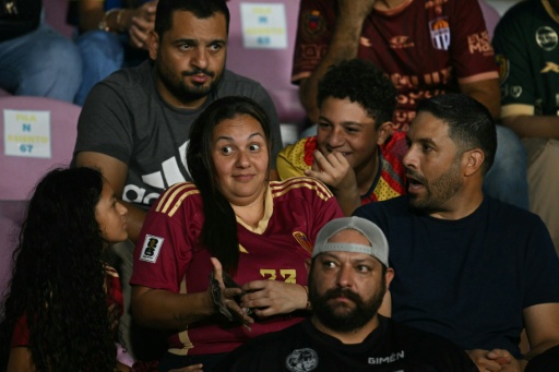 Lizmar Mejias (C) and Raymond Gosling (R) brought their children to the match. She said the manner in which the country has reacted to the tragedy has shown it in the best light — Federico PARRA / AFP
