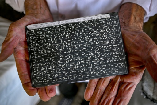 Kusman holds a tablet he engraved with the ancient Urartu language — Ozan KOSE / AFP