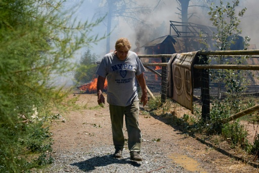 A resident walks near flames at La Bisbal de l’Emporda close to Spain's Costa Brava coast