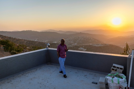 Qusai, the brother of US-Palestinian dual citizen Louai Abu Ridi, whose home in the occupied West Bank village of Qusra is besieged by Israeli settlers, walks on the roof of the home in Qusra — ilia YEFIMOVICH / AFP