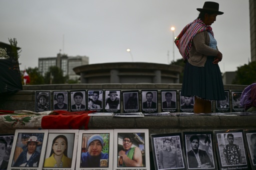 Une personne se tient à côté de photographies de victimes de crimes imputés à l'Etat péruvien, lors d’une veillée devant le Palais de Justice à Lima, le 27 juillet 2026 — Ernesto BENAVIDES / AFP