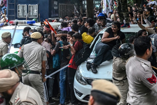 Des policiers tentent de disperser des militants du "Parti du peuple des cafards" (CJP) lors d'une manifestation réclamant la démission du ministre de l'Éducation, en raison de fraudes présumées aux examens universitaires, le 20 juillet 2026 à New Delhi, en Inde — Arun SANKAR / AFP