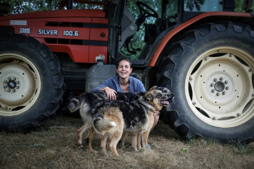 L'agricultrice Élodie Lac pose avec ses chiens dans sa ferme biologique à Cézac (Lot), le 19 août 2025 — Valentine CHAPUIS / AFP