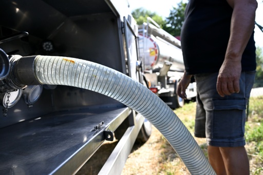 Un employé raccorde un tuyau à un camion-citerne transportant de l'eau potable pour approvisionner la commune de Sainte-Marie-aux-Mines, le 11 août 2026 dans le Haut-Rhin — Jean-Christophe VERHAEGEN / AFP