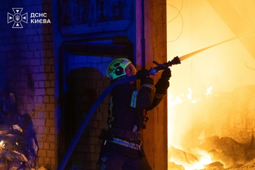 Photo prise et diffusée le 8 août 2026 par le service d’État ukrainien des situations d’urgence montrant un pompier luttant contre un incendie après des frappes de missiles balistiques russes à Kiev — handout / AFP