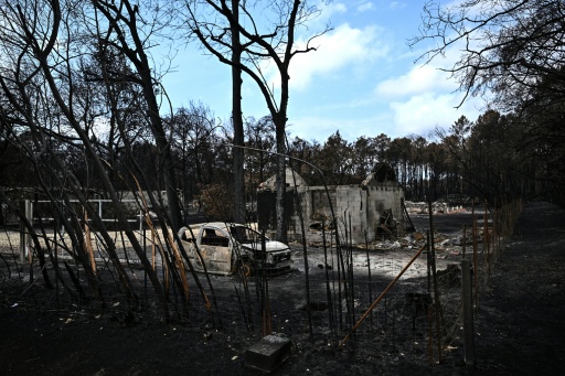 Une voiture calcinée devant une maison détruite par les flammes, le 3 août 2026 au Porge, en Gironde — Christophe ARCHAMBAULT / AFP
