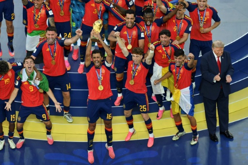Spain's midfielder #16 Rodri (front C) lifts the trophy with Spain's players next to US President Donald Trump (R) during the final ceremony after the 2026 World Cup — ANGELA WEISS / AFP