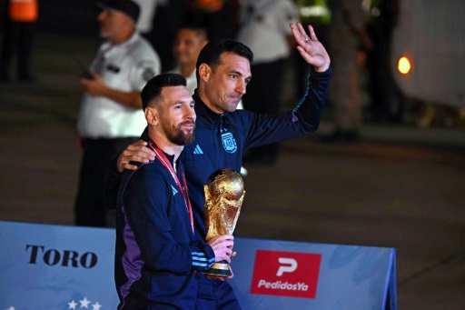El capitán de Argentina, Lionel Messi (izquierda), sostiene la Copa del Mundo junto al seleccionador argentino, Lionel Scaloni, a su llegada al Aeropuerto Internacional de Ezeiza tras ganar el Mundial de Catar 2022, en Ezeiza, provincia de Buenos Aires, el 20 de diciembre de 2022 — Luis ROBAYO / AFP