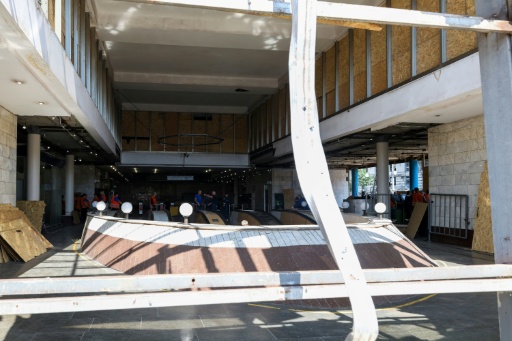 Los trabajadores municipales retiran los escombros del vestíbulo de una estación de metro dañada tras una andanada de ataques con misiles en Kiev el 19 de julio de 2026 — Serhii Okunev / AFP