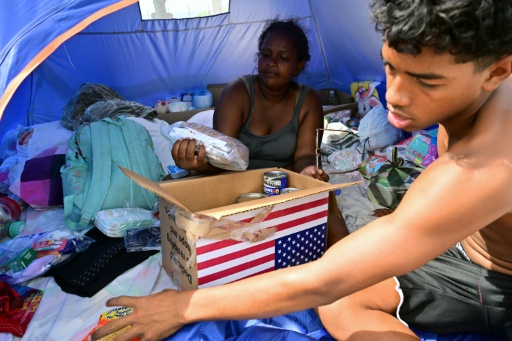 Des déplacés à la suite des séismes du 24 juin examinent le contenu d'un carton d'aide humanitaire américaine dans un centre d'accueil à Catia La Mar, dans l'Etat de La Guaira, au Venezuela, le 8 juillet 2026