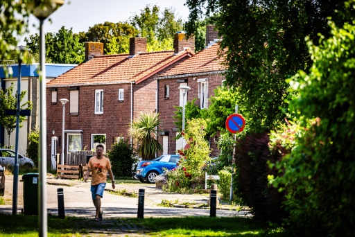 Un habitant marche dans une rue d’un quartier résidentiel du village de Moerdijk, dans le sud des Pays-Bas, le 22 juin 2026. Moerdijk est un village portuaire de 1.150 habitants placé entre les ports de Rotterdam et d'Anvers, en Belgique. C'est ici que le gouvernement néerlandais a choisi d'implanter une zone destinée à recevoir l'électricité produite par les parcs éoliens en mer et à rendre plus durable l'industrie portuaire du pays — Jeffrey Groeneweg / AFP