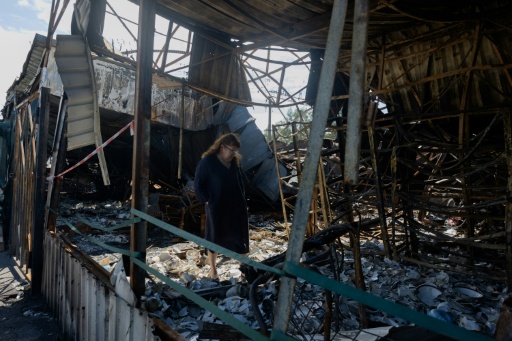 Shards of glass and porcelain crunch under feet as traders walk through the remains of their stalls — Tetiana DZHAFAROVA / AFP