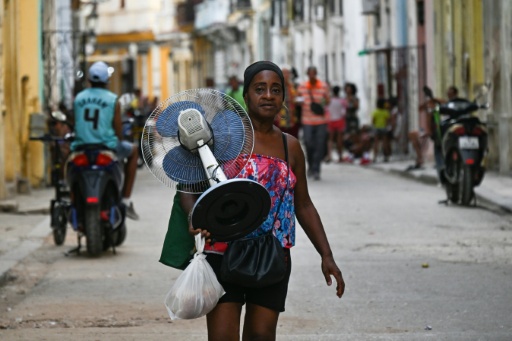 Una mujer lleva un ventilador por una calle de La Habana durante un apagón nacional, el 3 de agosto de 2026. La red eléctrica de Cuba colapsó el 2 de agosto de 2026, provocando un nuevo apagón en todo el país, según informó la empresa estatal de electricidad en una publicación en redes sociales. — YAMIL LAGE / AFP