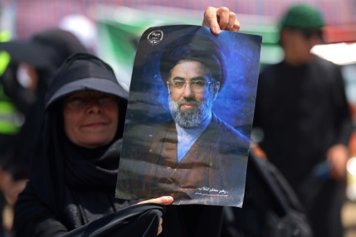 سيدة ترفع صورة المرشد الأعلى الإيراني مجتبى خامنئي بعد دخولها من إيران إلى العراق عبر معبر زرباطية لإحياء أربعينية الإمام الحسين، في 29 تموز/يوليو 2026 — أحمد الربيعي