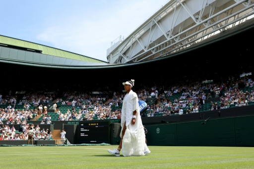 Naomi Osaka walks out before her third round match at Wimbledon