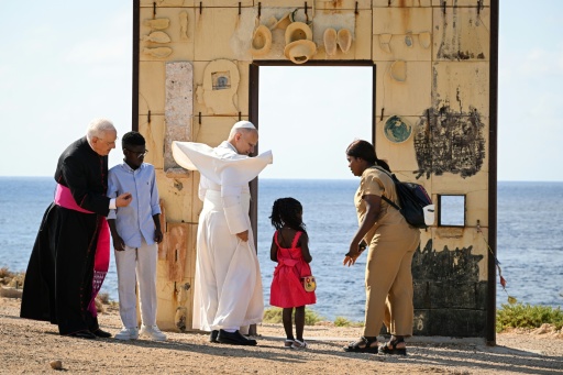 El papa León XIV (C) con una familia migrante junto al arco del monumento Puerta de Europa, realizado por el artista italiano Mimmo Paladino, durante una visita a la isla de Lampedusa, al sur de Sicilia, el 4 de julio de 2026