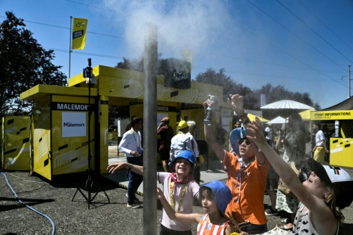 Children at a mist dispenser on the Tour de France with Sunday's ninth stage shortened because of the sweltering heat