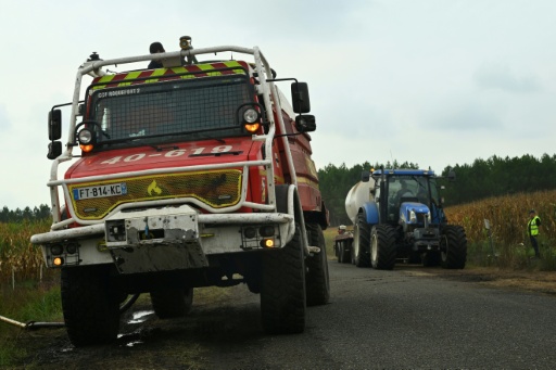 Des pompiers et des agriculteurs remplissent leurs citernes d'eau lors d'un feu de forêt à Luglon, le 16 août 2026 dans les Landes — Gaizka IROZ / AFP