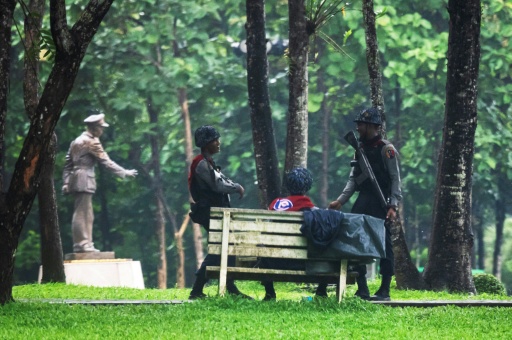 Policemen stand guard next to a statue of General Aung San at the Bogyoke Aung San Park in Yangon — - / AFP