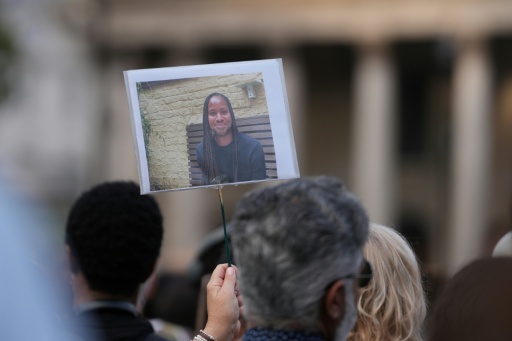 Supporters hold up a photo of Jason Arday during a a vigil for the late Cambridge professor in London's Trafalgar Square — CARLOS JASSO / AFP