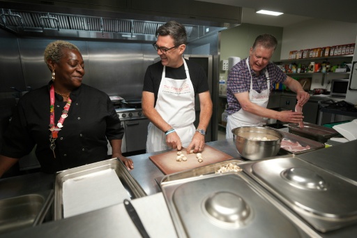 El líder del Partido Laborista británico, Andy Burnham (c), corta champiñones en un comedor benéfico en Londres el 20 de julio de 2026, antes de asumir el cargo de primer ministro — Christopher Furlong / AFP