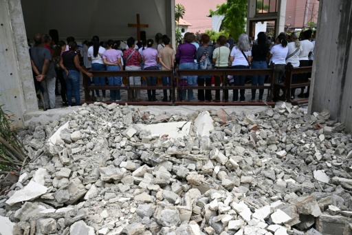 People attend a mass at the Jerusalem square in Maiquetia, Venezuela, as attention turns to mourning and burials following the June 24 twin earthquakes